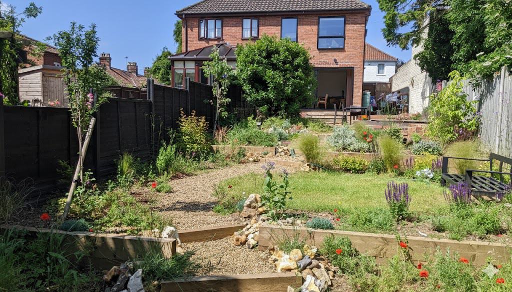 Norfolk garden design. Beautiful terraced Norfolk garden with lush plants and outdoor seating area. Expert garden design tailored to Norfolk by Richard Walters landscapes.